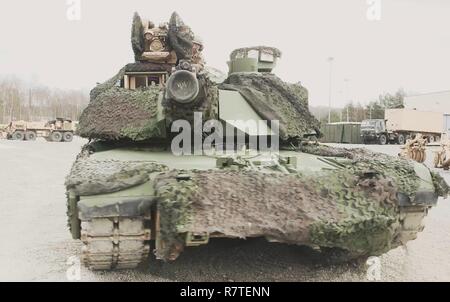 Ein M1 Abrams tank Crew aus der Schlacht Unternehmen, 1 Battalion, 66th Panzer Regiment, 3. gepanzerte Brigade Combat Team, 4 Infanterie Division, rollt von einer Bucht mit einer frisch lackierten neuer Blick auf grafenwöhr Training Area, Germany, April 7, 2017. Die 3 ABCT, 4. Inf. Div., hat damit begonnen, die Annahme eines Woodland camouflage Look günstiger für die Europäische Umwelt Es bildet derzeit in als Teil des Atlantiks zu lösen, und alle seine Bekämpfung der Fahrzeuge werden von Tan in den nächsten Monaten gestrichen werden. Stockfoto