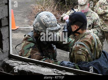 Us-Armee Pfc. Sung Hoon Lee, 2.BATAILLON, 1 Air Defense Artillery Medic, simuliert die Dekontaminierung von einem Soldaten während der 35Th Air Defense Artillery Brigade Experte Bereich Medizinische Abzeichen vorentscheidung am Osan Flughafen, der Republik Korea, April 6, 2017. Während des Wettbewerbs hatten die Teilnehmer zwei bekämpfen trauma Gassen zu überwinden, testen die Fähigkeiten des Medic, Entschlossenheit und Stärke durch Szenarien, wie z. B. medizinische Betreuung, Pflege unter Feuer, taktische Bewegung, Dekontaminierung und Wurf Bewegung. Stockfoto