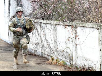 Us-Armee Pfc. Sung Hoon Lee, 2.BATAILLON, 1 Air Defense Artillery Medic, läuft einer der beiden bekämpfen trauma Gassen während der 35Th Air Defense Artillery Brigade Experte Bereich Medizinische Abzeichen vorentscheidung am Osan Flughafen, der Republik Korea, April 6, 2017. In den Gassen, die Fähigkeiten der Teilnehmer, Entschlossenheit und Stärke wurden durch Szenarien, wie z. B. medizinische Betreuung, Pflege unter Feuer, taktische Bewegung, Dekontaminierung und Wurf Bewegung getestet. Stockfoto