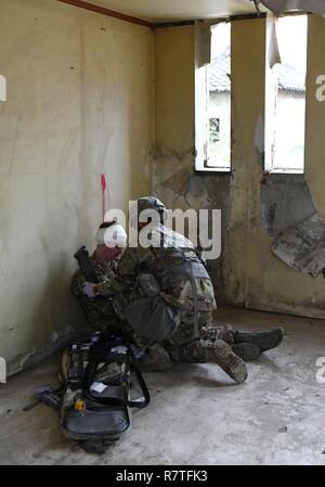 U.S. Army Staff Sgt. Santiago Sendejas, 6 Battalion, 52nd Air Defense Artillery medizinische NCO, behandelt einen simulierten Unfall während der 35Th Air Defense Artillery Brigade Experte Bereich Medizinische Abzeichen vorentscheidung am Osan Flughafen, der Republik Korea, April 6, 2017. Das Ziel des Wettbewerbs war es, zusammen zu bringen, die Ärzte für Training und bestimmen, welche die Fähigkeit und Entschlossenheit bei der 8. Armee Experte Bereich Medizinische Abzeichen, den Wettbewerb zu gewinnen. Stockfoto