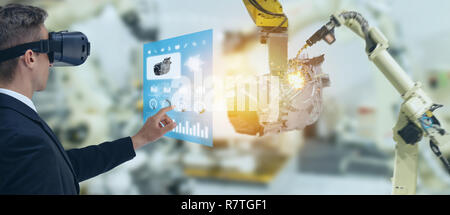 Iot Industrie 4.0 Konzept, Wirtschaftsingenieur mit smart Gläser mit Augmented und Virtual Reality Technologie zur Überwachung der Maschine in Echtzeit ti gemischt Stockfoto