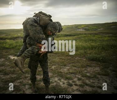 MARINE CORPS BASE CAMP PENDLETON, Kalifornien-Lance Cpl. Kobe Loonsfoot, eine Landung-Support-Spezialist mit Combat Logistik-Bataillon 15, 15. Marine Expeditionary Unit, trägt ein Kerl Marine während eines Kampfes Leben Sparer Kurs teils PHIBRON MEU Integrationsschulung in Camp Pendleton, 6. April 2017.  Diese erste Übung auf See bietet die Marines die Möglichkeit, Praxis Integration mit Navy Gegenstücke bilden ein effizientes Team in der Lage, eine Reihe von Missionen rund um den Globus zu erreichen. Diese Navy Marine Corps-Team unterstützt Kampfkommandanten bei der Aufrechterhaltung der regionalen maritimen s Stockfoto