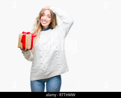 Schöne, junge blonde Frau mit Geschenk über isolierte Hintergrund mit Hand betonte am Kopf, mit Scham und Überraschung Gesicht schockiert, wütend und frustra Stockfoto