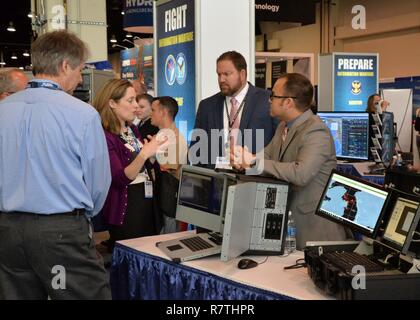 National Harbor, MD (Apr. 4, 2017) Platz und Naval Warfare Systems Center Pacific Ingenieure Brad Reiman, Mitte, und Paul Baggerly, rechts, diskutieren die Intelligenz auf Programm (ICOP) mit interessierten Besuchern in der Marine Information Warfare Pavillon am See-, Luft- und Raumfahrt (SAS). Die Information Warfare Pavillon ist durch eine Partnerschaft zwischen dem Büro des stellvertretenden Leiters der Naval Operations für Information Warfare (OPNAV N2-N6); Kommandeur, US-Flotte Cyber Command/Commander, U.S. 10 Flotte (CFCC/C 10 F); Raum und Naval Warfare Systems Command (Spawar) und Commander, Naval Informieren vorgestellt Stockfoto