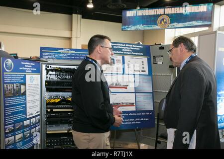 NATIONAL HARBOR, Md., (3. April 2017) Cmdr. James Hammond, Information Assurance Manager bei der Marine taktische Netze Program Office (PMW 160) gibt einen Überblick über die konsolidierte Flott Netzwerk Enterprise Services (Stöcke) System um einen Teilnehmer an der Marine Liga Sea-Air-Space Exposition. Stöcke wurde auf Anzeige als Teil der Marine Information Warfare Pavillon. PEO C4I und seine Partner Programm Büros vier Demonstrationen inklusive Stöcke, ein Programm, das von PMW 160 verwaltet. Stockfoto