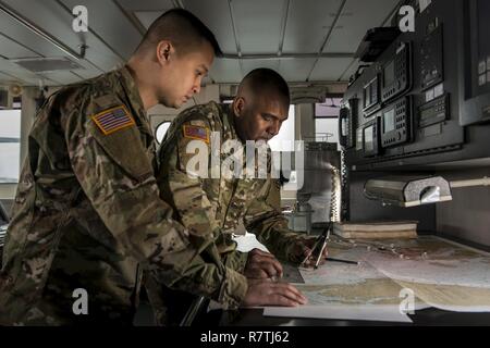 Spc. Huy Dinh und Sgt. Nigel Sonnylal, U.S. Army Reserve watercraft operator Soldaten des 949Th Transportation Company, eine Einheit, die in watercraft Operationen, Fracht- und Wasserfahrzeuge Engineering spezialisiert, Stellen mit einem wasserfahrzeug Chart und Tools für eine Serie von Portraits, die sich an Bord eines Schiffes für die logistische Unterstützung in Baltimore, Md., April 7-8, 2017. Stockfoto
