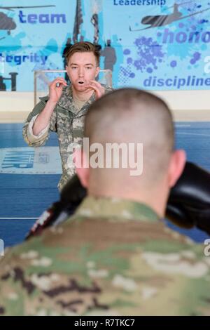 Us-Armee SPC. Christopher Laughlin, wird fertig, eingehende Stanzen von Sgt. Joe Primeau, Assistant Instructor, als er die Klammern Bohren, bei dem die Schüler ihre Gegner zu halten, um eingehende Schläge zu stoppen, für eine combatives Ebene eine Klasse auf chièvres Air Base, Belgien, 22. März 2017 unterrichtet. Beide Soldaten sind mit afnorth Bataillon, USANATO Brigade die Einheit, led, diese Klasse zu militärischen Kräfte in den Benelux-staaten stationiert. Stockfoto