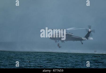 Marine Special Operations Schule Individuelle Schulung Studenten helocast von einem US-Marine SH-60 Seahawk Hubschrauber, 23. März 2017, im Key West, Fla. Zum ersten Mal, US Air Force Special Taktik Flieger drei Monate im ersten Marine Special Operations Command Marine Raider Ausbildung Pipeline ausgegeben, die Bemühungen um gemeinsame Denkweisen über Special Operations Forces zu errichten. Stockfoto