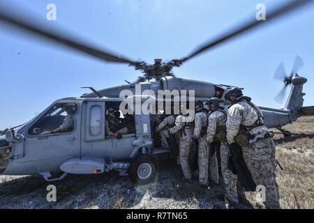 Marine Special Operations Schule Individuelle Schulung Studenten Last auf einem US-Marine SH-60 Seahawk Hubschrauber für helocasting Training, 23. März 2017, im Key West, Fla. Zum ersten Mal, US Air Force Special Taktik Flieger drei Monate im ersten Marine Special Operations Command Marine Raider Ausbildung Pipeline ausgegeben, die Bemühungen um gemeinsame Denkweisen über Special Operations Forces zu errichten. Stockfoto