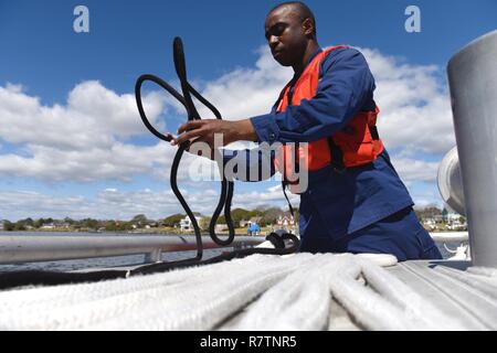 Coast Guard Petty Officer 3. Klasse James Rodgers-Woodard, einer Maschinen Techniker an der Station Emerald Isle, Nord-Carolina, bereitet die Linien für die abschleppen Übung an Bord eines 45-Fuß-Antwort Boat-Medium in Bogue Inlet, 27. März 2017. Station Emerald Isle Bootscrews oft Verhalten abschleppen Ausbildung ihre Leistungsfähigkeit während real-life Notfälle zu erhalten. Stockfoto