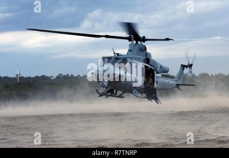 Marines mit Hotel Company, 2 Raider Bataillon, Marine Corps Forces Special Operations Command (MARSOC) in Camp Lejeune in North Carolina, in einer UH-1Y Venom Hubschrauber während einer Übung auf der Basis, 28. März 2017. Ein 45-Fuß-Antwort Boat-Medium Crew von der Coast Guard Station Wrightsville Beach, North Carolina, sofern Waterside unterstützen, während die Marines wiederholt vom Hubschrauber und schwamm ans Ufer sprang. Stockfoto