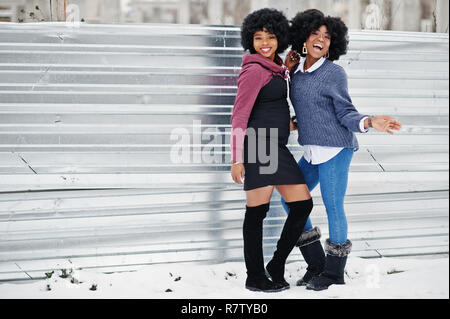 Zwei lockiges Haar afrikanische amerikanische Frau tragen auf pullovern im Winter Tag gestellt. Stockfoto