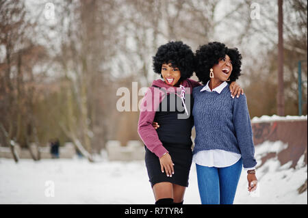 Zwei lockiges Haar afrikanische amerikanische Frau tragen auf pullovern im Winter Tag gestellt. Stockfoto