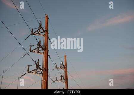 Strommasten und Hochspannungsleitungen bei Sonnenuntergang in Wyoming, USA Stockfoto