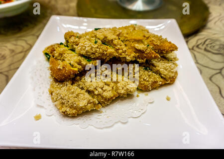 Gebratene chinesische Jiucai Hezi mit Krümel auf eine weisse Platte Stockfoto