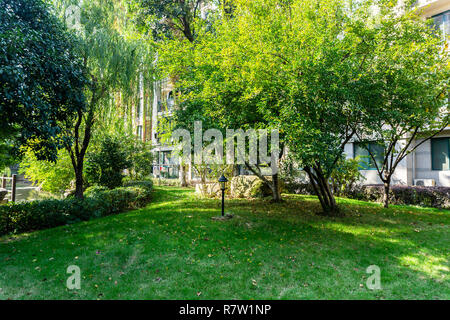 Garten Leuchten auf Gras mit Bäumen und Apartment Gebäude im Hintergrund Stockfoto