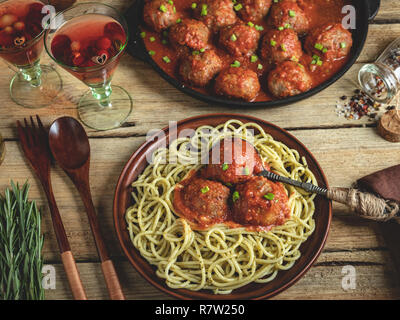 Hausgemachten Fleischklößchen in Tomatensauce mit Nudeln auf einem Teller. Pfanne auf einer hölzernen Oberfläche Stockfoto