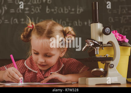 Schülerin arbeiten zur Biologie Forschung mit Mikroskop. Kleines Mädchen studieren in der Biologie Klassenzimmer in der Schule, vintage Filter Stockfoto