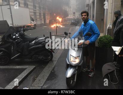 Dezember 01, 2018 - Paris, Frankreich: Jimmy Crombez, eine 32-jährige Besitzer eines Start-up, versucht seinem Roller zu nehmen, weg von der Straße, wo er lebt, wo mehrere Fahrzeuge in Brand gesetzt worden sind. Un habitant recupere Sohn scooter pour l'eloigner tandis que des gilets Jaunes et des casseurs mettent Le tau Ein des Véhicules dans sa rue de Marge d e l'Acte 3des gilets Jaunes a Paris. Cette Manifestation einer Rapidement degenere en affrontement avec les CRS filtrant l'entrée de l'Avenue des Champs-Elysees. *** Frankreich/KEINE VERKÄUFE IN DEN FRANZÖSISCHEN MEDIEN *** Stockfoto