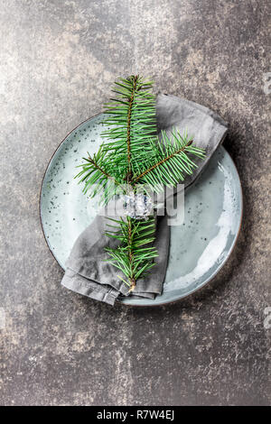 Urlaub Weihnachten Lebensmittel Hintergrund, Besteck, Teller, Servietten mit Ring und Weihnachten Baum, Tisch Einstellung in Silber Ton, Stein Stockfoto