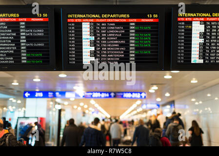 Istanbul, Türkei - 29 Dezember, 2017 Flughafen Istanbul Atatürk internationale Abflüge Monitore mit Toren und Defokussierten Menschen. Stockfoto