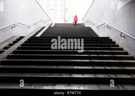 U-Bahn Treppe Charkow, Ukraine und eine Frau mit roten Mantel es klettern. Stockfoto