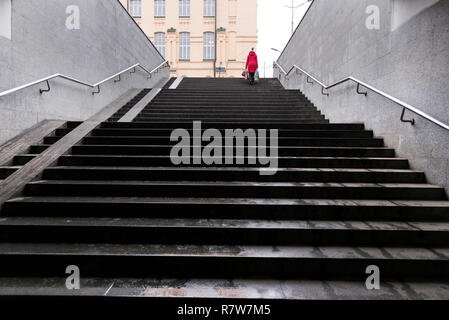 U-Bahn Treppe Charkow, Ukraine und eine Frau mit roten Mantel es klettern. Stockfoto
