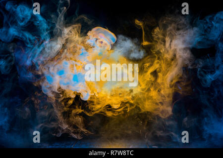 Gelber und blauer Rauch Muster auf dunklem Hintergrund Stockfoto