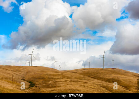 Windkraftanlagen stehen in krassem Kontrast zu den dunklen Wolken entlang den Hügeln in der Nähe von Goldendale, Washington, in der Columbia River Gorge. Stockfoto