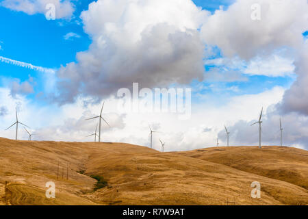 Windkraftanlagen stehen in krassem Kontrast zu den dunklen Wolken entlang den Hügeln in der Nähe von Goldendale, Washington, in der Columbia River Gorge. Stockfoto