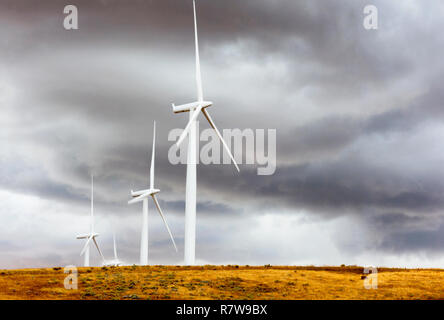 Windkraftanlagen stehen in krassem Kontrast zu den dunklen Wolken entlang den Hügeln in der Nähe von Goldendale, Washington, in der Columbia River Gorge. Stockfoto