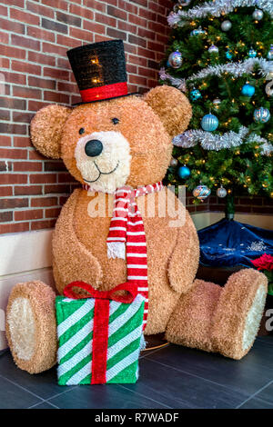 Es ist Dezember, Weihnachten - Bunte große Marionette Puppe Spielzeug Teddy Bär mit Geschenk Stockfoto