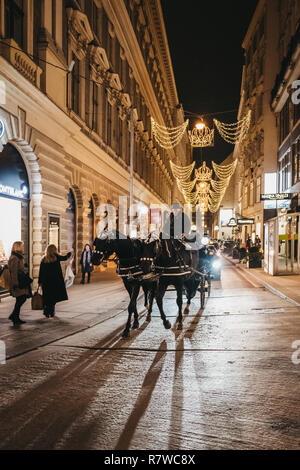 Wien, Österreich - November 24, 2018: Pferdekutsche Tour auf einer Straße in Wien, Österreich, am Abend. Diese Touren sind sehr beliebt bei Touristen Stockfoto