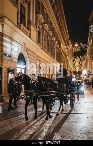 Wien, Österreich - November 24, 2018: Pferdekutsche Tour auf einer Straße in Wien, Österreich, am Abend. Diese Touren sind sehr beliebt bei Touristen Stockfoto