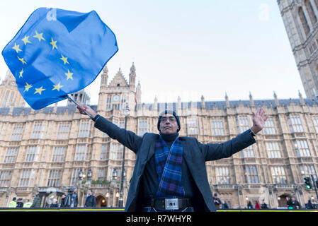 London, Großbritannien. 11. Dezember 2018. Ein anti-Brexit demonstrator Wellen eine europäische Flagge vor dem Unterhaus. Theresa May, Premierminister, tourt durch europäische Hauptstädte, um zu versuchen, die Brexit Abkommen mit der Europäischen Union nach der heutigen sinnvolle Abstimmung durch die MP's War latente verhandeln. Credit: Stephen Chung/Alamy leben Nachrichten Stockfoto