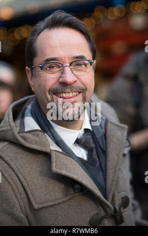 SYMBOL - 11. Dezember 2018, Nordrhein-Westfalen, Münster: Der Schauspieler Jan Josef Liefers in der Rolle von Prof. Karl-Friedrich Boerne lacht auf dem Weihnachtsmarkt zu einem Fotoshooting für die neuen Tatort (ARD) 'Dann e der Mörder vor der Tür'. Foto: Friso Gentsch/dpa Stockfoto