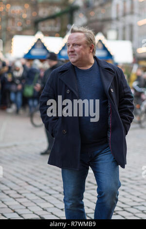 SYMBOL - 11. Dezember 2018, Nordrhein-Westfalen, Münster: Die Schauspieler Axel Prahl als Kommissar Frank Thiel geht über den Weihnachtsmarkt zu einem Fotoshooting für die neuen Tatort (ARD) ann'de der Mörder vor der Tür'. Foto: Friso Gentsch/dpa Stockfoto