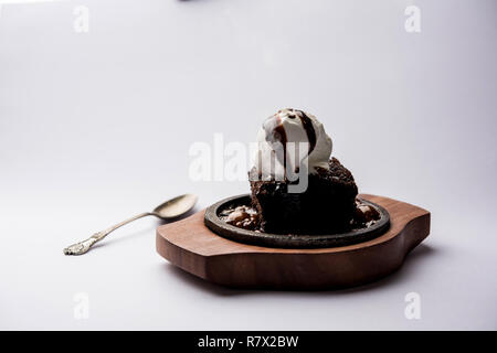 Sizzling Chocolate Brownie ist eine Süßspeise, die mit Kugel Eis-Creme auf der Oberseite mit einem großzügigen Gießen der geschmolzene Schokolade serviert. Server heiß. wählen Stockfoto