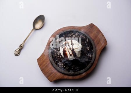 Sizzling Chocolate Brownie ist eine Süßspeise, die mit Kugel Eis-Creme auf der Oberseite mit einem großzügigen Gießen der geschmolzene Schokolade serviert. Server heiß. wählen Stockfoto