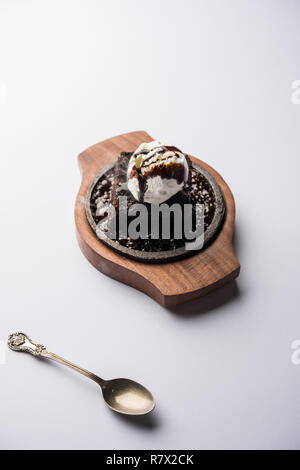 Sizzling Chocolate Brownie ist eine Süßspeise, die mit Kugel Eis-Creme auf der Oberseite mit einem großzügigen Gießen der geschmolzene Schokolade serviert. Server heiß. wählen Stockfoto