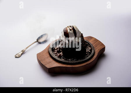 Sizzling Chocolate Brownie ist eine Süßspeise, die mit Kugel Eis-Creme auf der Oberseite mit einem großzügigen Gießen der geschmolzene Schokolade serviert. Server heiß. wählen Stockfoto