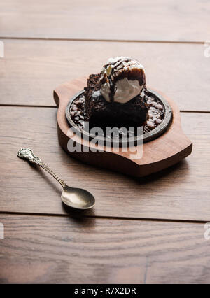 Sizzling Chocolate Brownie ist eine Süßspeise, die mit Kugel Eis-Creme auf der Oberseite mit einem großzügigen Gießen der geschmolzene Schokolade serviert. Server heiß. wählen Stockfoto