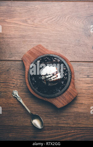 Sizzling Chocolate Brownie ist eine Süßspeise, die mit Kugel Eis-Creme auf der Oberseite mit einem großzügigen Gießen der geschmolzene Schokolade serviert. Server heiß. wählen Stockfoto