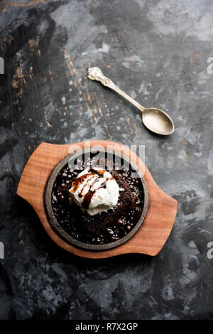 Sizzling Chocolate Brownie ist eine Süßspeise, die mit Kugel Eis-Creme auf der Oberseite mit einem großzügigen Gießen der geschmolzene Schokolade serviert. Server heiß. wählen Stockfoto