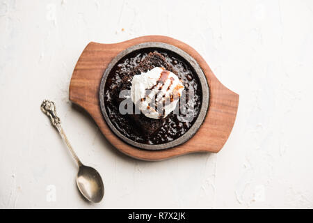 Sizzling Chocolate Brownie ist eine Süßspeise, die mit Kugel Eis-Creme auf der Oberseite mit einem großzügigen Gießen der geschmolzene Schokolade serviert. Server heiß. wählen Stockfoto