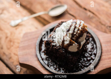Sizzling Chocolate Brownie ist eine Süßspeise, die mit Kugel Eis-Creme auf der Oberseite mit einem großzügigen Gießen der geschmolzene Schokolade serviert. Server heiß. wählen Stockfoto
