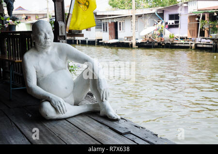 Eine Statue von einem thailändischen Mann in weiß lackiert, durch den Fluss Chao Phraya im Baan Silapin Artist's House, Bangkok, Thailand Stockfoto