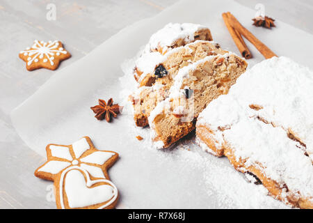 Die traditionellen Christstollen mit Lebkuchen, Zimt, Anis Sterne auf grau Holztisch. Schuß im Winkel. Stockfoto