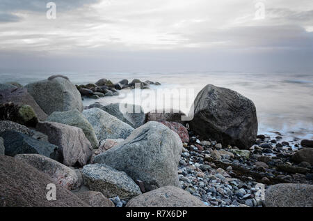 Steine an der Küste im Meer, sanfte Wellen, die durch die Langzeitbelichtung, kopieren Raum Stockfoto