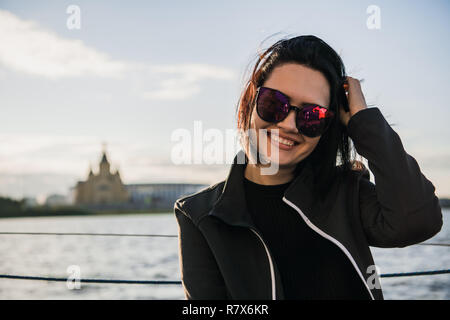 Schöne Frauen ihre freie Zeit genießen durch den Fluss. Mädchen Outdoor Lifestyle. Junge Frau mit schwarzen Haaren Sonnenbrille tragen. Stockfoto